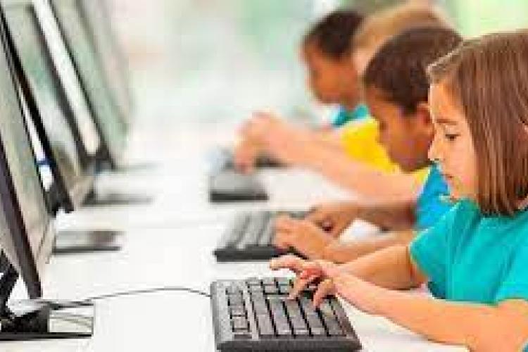 Un grupo de escolares, utilizando ordenador en el aula.